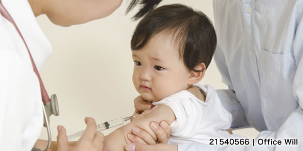 注射を嫌がる赤ちゃんと医療従事者